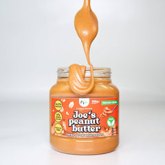 Spoonful of Joe's Peanut Butter dripping back into jar