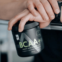 a person holding a jar of bcaa