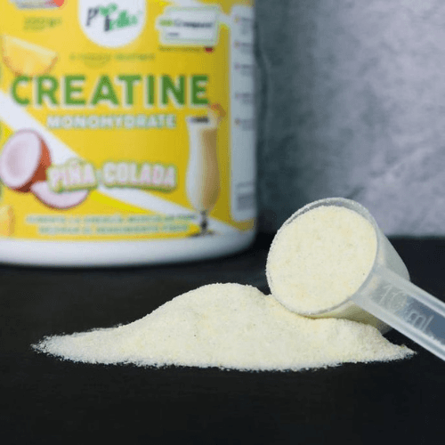 a bottle of creatine next to a pile of sugar