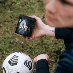 a person holding a cup of coffee next to a soccer ball