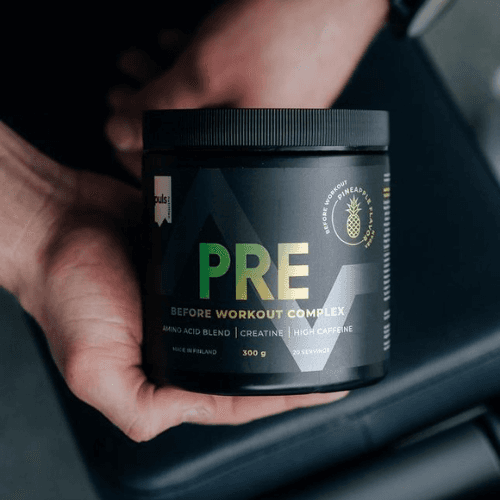 a person holding a jar of pre workout complex